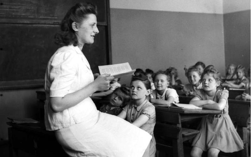 Lehrerin lesend vor einer Grundschulklasse