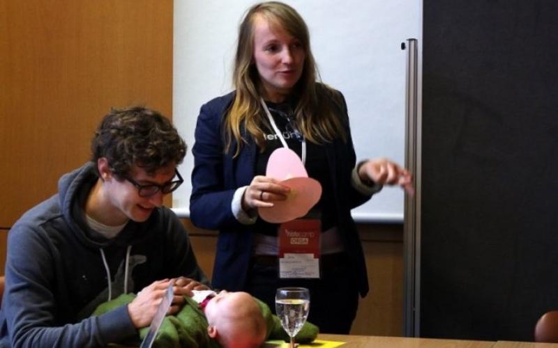 Janine Funke bei einem Vortrag mit Ihrer Tochter Emilia, die von ihrem Mann betreut wird