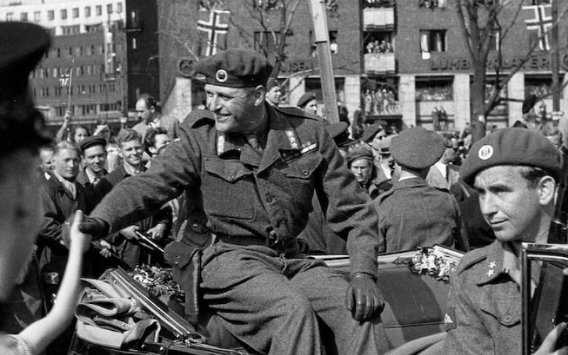 Kronprinz Olav bei seiner Rückkehr nach Norwegen, 13.05.1945; vor ihm sitzend (rechts im Bild) Max Manus