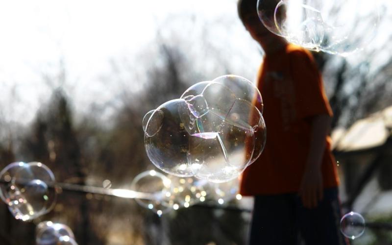 Seifenblasen im Sonnenlicht mit Kindersilhouette