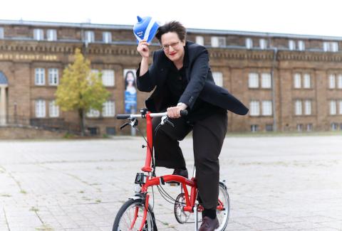 Museumsleiterin Sylvia Necker auf ihrem roten Klapprad auf dem Platz vor dem Museum