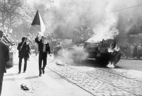 Einwohner von Prag mit tschechoslowakischer Flagge vor einem sowjetischen Panzer