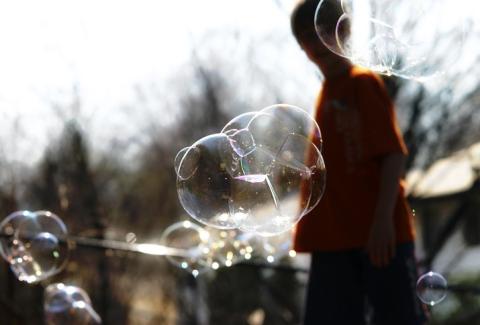 Seifenblasen im Sonnenlicht mit Kindersilhouette